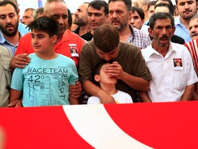 A relative comforts the son of a police officer killed Friday during the failed military coup in Turkey.