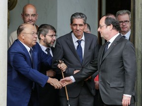 French President Francois Hollande shakes hands with Paris Mosque rector Dalil Boubakeur, left, after a meeting with religious representatives at the Elysee Palace in Paris, following yesterday attack at a church in Normandy, Wednesday, July 27, 2016. The Islamic State group crossed a new threshold Tuesday in its war against the West, as two of its followers targeted a church in Normandy, slitting the throat of an elderly priest celebrating Mass and using hostages as human shields before being shot by police.