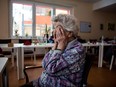 Day guest Helga covered her face with her hands the middle of the room in the geriatric day care facility of the German Red Cross at Villa Albrecht on March 11, 2013 in Berlin, Germany. A great number of senior Citzens struggle with various forms of dementia at Villa Albrecht.