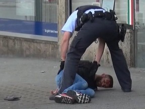 In this grab taken from video, police arrest a man in Reutilingen, Germany on Sunday. A Syrian man killed a woman with a machete and wounded two others Sunday outside a bus station in the city before being arrested.