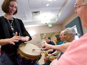 Music therapist Heather Davidson, left, plays a drum with Claire Diering, right, during a drum circle with patients with Alzheimer's disease at the Copper Ridge Care Center in Sykesville, Maryland in an October 23, 2009 file photo.