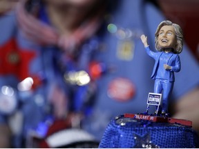 A delegate wears a hat with a bubble-head doll of Democratic Presidential candidate  Hillary Clinton during the first day of the Democratic National Convention in Philadelphia .