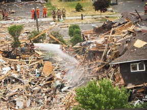 Debris litters a street after a house explosion in Mississauga, Ont., Tuesday, June 28, 2016.