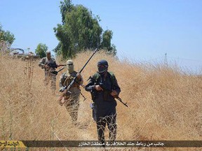 In this 2015 photo, ISIL militants patrol Khazer, Iraq, near Mosul