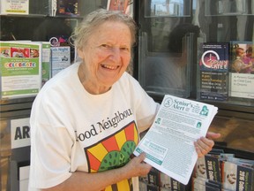 Mary Stanko holding her newsletter, Senior's Alert, at the library.