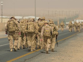 Royal Canadian Air Force members perform a ruck march to simulate the evacuation of a CP-140 Aurora during Operation IMPACT in Kuwait on February 9, 2015