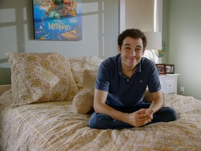 Owen Suskind in his bedroom, flanked by Ariel.