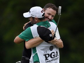 Jimmy Walker hugs caddie Andy Sanders after his putt for par fell on the 18th hole to win the 2016 PGA Championship at Baltusrol Golf Club on July 31, 2016.