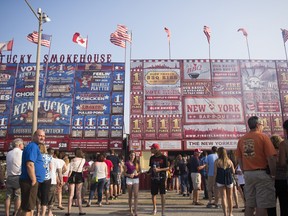 People line up to get a taste of some ribs at Welland's first Ribfest at the Niagara Regional Exhibition and Fairgrounds on Saturday July 11, 2015 in Welland, Ont.