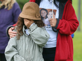 A child gestures during a vigil for Sara Baillie and her daughter Taliyah Marsman at Sandstone Park in Calgary on Sunday, July 17, 2016.