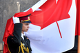An Ukrainian guard of honour soldier holds a Canadian flag during a welcoming ceremony for Prime Minister of Canada Justin Trudeau in Kyiv on June 11, 2016.