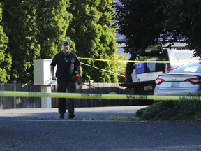 An investigator works at the scene of a multiple murder in the Chenault Beach neighborhood of Mukilteo, Wash., Saturday July 30, 2016.