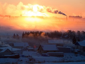 The rising sun illuminates buildings and industrial chimney emissions at sunrise in Yakutsk, Russia. Warming temperatures in Siberia are thought to be releasing once-dormant bacteria and viruses.