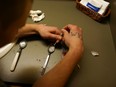 Drugs are prepared to shoot intravenously by a user addicted to heroin on February 6 in a file photo.