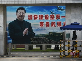 A soldier stands guard in front of a huge portrait of Chinese President Xi Jinping at the entrance to a military base in Guilin, in China's southern Guangxi region on May 13, 2016.
The slogan reads "Speed up the establishment of a powerful people's Air Force and sharpen offensive and defensive capabilities".