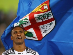 The Fiji national flag flutters next to captain Jerry Tuwai before Thursday's men's rugby sevens gold medal match in Rio, where Fiji won its first Olympic medal.
