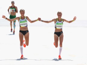 Anna Hahner (L) of Germany and her sister Lisa Hahner approach the finish line during the Women's Marathon on Day 9 of the Rio 2016 Olympic Games at the Sambodromo on August 14, 2016 in Rio de Janeiro, Brazil.