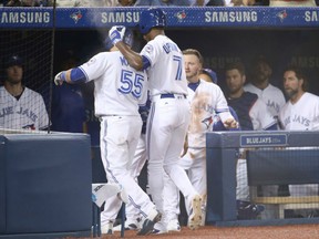 Russell Martin, left, of the Blue Jays is congratulated by Melvin Upton Jr., whose sacrifice fly drove home Martin in the fifth inning against the Los Angeles Angels on Tuesday night at Rogers Centre in Toronto.
