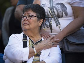 Sixties Scoop survivor Dokis Thibault holds her daughter's hand as she gets emotional during a rally in Toronto on Tuesday, Aug. 23, 2016. Scores of aboriginals from across Ontario rallied in Toronto ahead of a landmark court hearing on the so-called '60s Scoop.