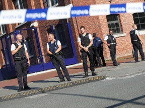 Police stand as they secure the area around a police building in the southern Belgian city of Charleroi following a machete attack on August 6, 2016. 
A machete-wielding man who wounded two policewomen on August 6, in the southern Belgian city of Charleroi has died after being shot by officers.