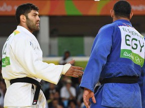 Israel's Or Sasson (white) competes with Egypt's Islam El Shehaby during their men's +100kg judo contest match of the Rio 2016 Olympic Games in Rio de Janeiro on August 12, 2016.