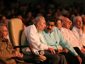 Former Cuban President Fidel Castro (2nd L), sitting between Venezuelan President Nicolas Maduro (3rd L) and Cuban President Raul Castro (L), is seen attending the celebration of his 90th birthday at the Karl Marx Theatre in Havana on August 13, 2016.