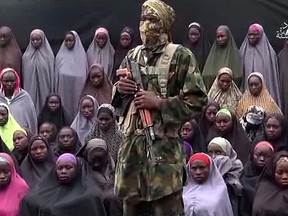 This screen grab taken from a video released purportedly by Islamist group Boko Haram showing fighters standing in front of girls allegedly kidnapped from Chibok