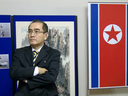 In a video grab created on August 17, 2016 taken from footage recorded by AFPTV on November 3, 2014 deputy ambassador at the North Korean embassy in London, Thae Yong-ho, stands in front of an artwork during a photocall to view an exhibition of North Korean art at the North Korean embassy in west London.