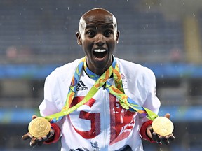 Gold medallist Mo Farah celebrates near the podium for the Men's 5000m during the athletics event at the Rio 2016 Olympic Games at the Olympic Stadium in Rio de Janeiro on August 20, 2016.