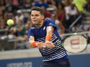 Milos Raonic of Canada hits a return to Dustin Brown of Germany during their opening-round match at the U.S. Open on Monday in New York.