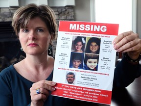 Alison Azer holds up a poster showing her four children Sharvahn,11, Rojevahn, 9, Dersim, 7, and Meitan, 3, that were abducted by their father Saren Azer.