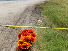 Flowers sit next to police tape at the site of Saturday's hot air balloon crash near Lockhart, Texas, Sunday, July 31, 2016.