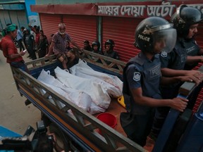 Bangladesh policemen drive off in a mini truck with bodies after a raid near Dhaka, Bangladesh, Saturday, Aug. 27, 2016