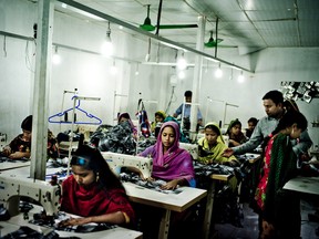 Workers sew garments at an unregistered factory in Dhaka, Bangladesh, Nov. 17, 2013.