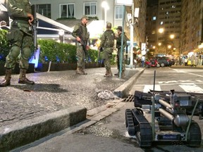Members of Brazil's armed forces stand on duty as bomb disposal equipment is packed away following a controlled explosion in the Copacabana district.