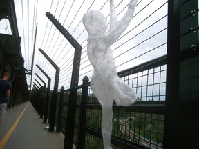 A human-like figure made of tape hangs from a safety fence on High Level Bridge in Edmonton on Sunday, August 7, 2016