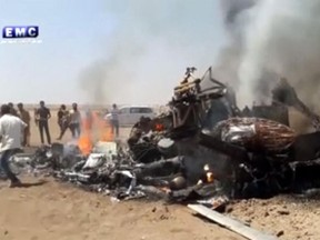 This image made from video provided by Thiqa news agency, which has been verified and is consistent with other AP reporting, purports to show people gathered around the burning wreckage of a Russian helicopter downed in Syria on Monday, Aug. 1, 2016.