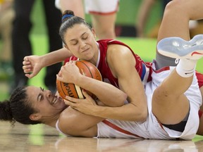 Canada's Kia Nurse (bottom) and Serbia's Sasa Cado fight over a loose ball during their preliminary round basketball match at the 2016 Summer Olympics on Monday, Aug. 8, 2016 in Rio. Nurse led Canada with 25 points in the four-point victory.