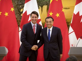 Canada's Prime Minister Justin Trudeau, left, and China's Premier Li Keqiang, right, shake hands as they pose for a photo at the end of a joint press conference at the Great Hall of the People in Beijing, Wednesday, Aug. 31, 2016.