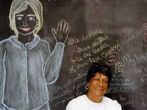 Ivy Hall, 86, from Richmond, Va., sits in front of a chalkboard with the likeness of Hillary Clinton, while waiting for her son volunteering at a Democratic office in Virginia