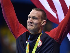 USA's Ryan Held cries while standing with his gold medal on the podium of the Men's 4x100m Freestyle Relay Final