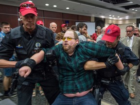 A protester is removed from the Energy East hearings in Montreal on Monday.