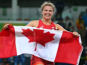 Erica Weibe of Canada carries the flag after defeating Guzel Manyurove of Kazakhstan