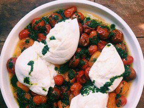 Roasted cherry tomatoes with burrata and basil oil.