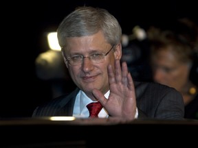 Canadian Prime Minister Stephen Harper waves before getting in his car as he arrives in Brisbane, Australia for the G20 Summit Friday, November 14, 2014.