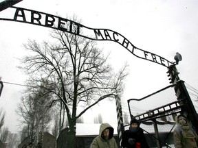 In a Jan. 26, 2005 file photo, visitors walk under the notorious "Arbeit Macht Frei" sign at the entrance gate of the Auschwitz Nazi concentration camp in Oswiecim, southern Poland.