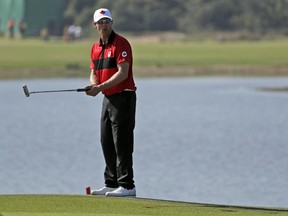 Canadian golfer Graham DeLaet putts on the second hole during the final round of the men's golf event at the 2016 Summer Olympics in Rio de Janeiro, Brazil, on Sunday, Aug. 14, 2016.