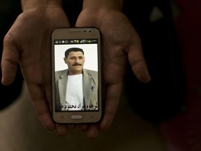 In this Wednesday, May 18, 2016 photo, a relative shows a phone picture of Murat Mahmoud during an interview with the Associated Press at Kankhe Camp for the internally displaced in Dahuk, northern Iraq.
