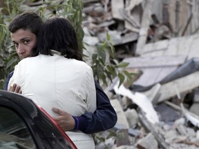 Two people hug each other next to the remains of a collapsed house following an earthquake in Pescara Del Tronto, Italy, Wednesday, Aug. 24, 2016.