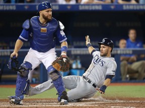 Kevin Kiermaier of the Tampa Bay Rays slides safely into home plate ahead of Toronto Blue Jays' catcher Russell Martin during MLB action Tuesday night at Rogers Centre. The Rays were 9-2 winners.